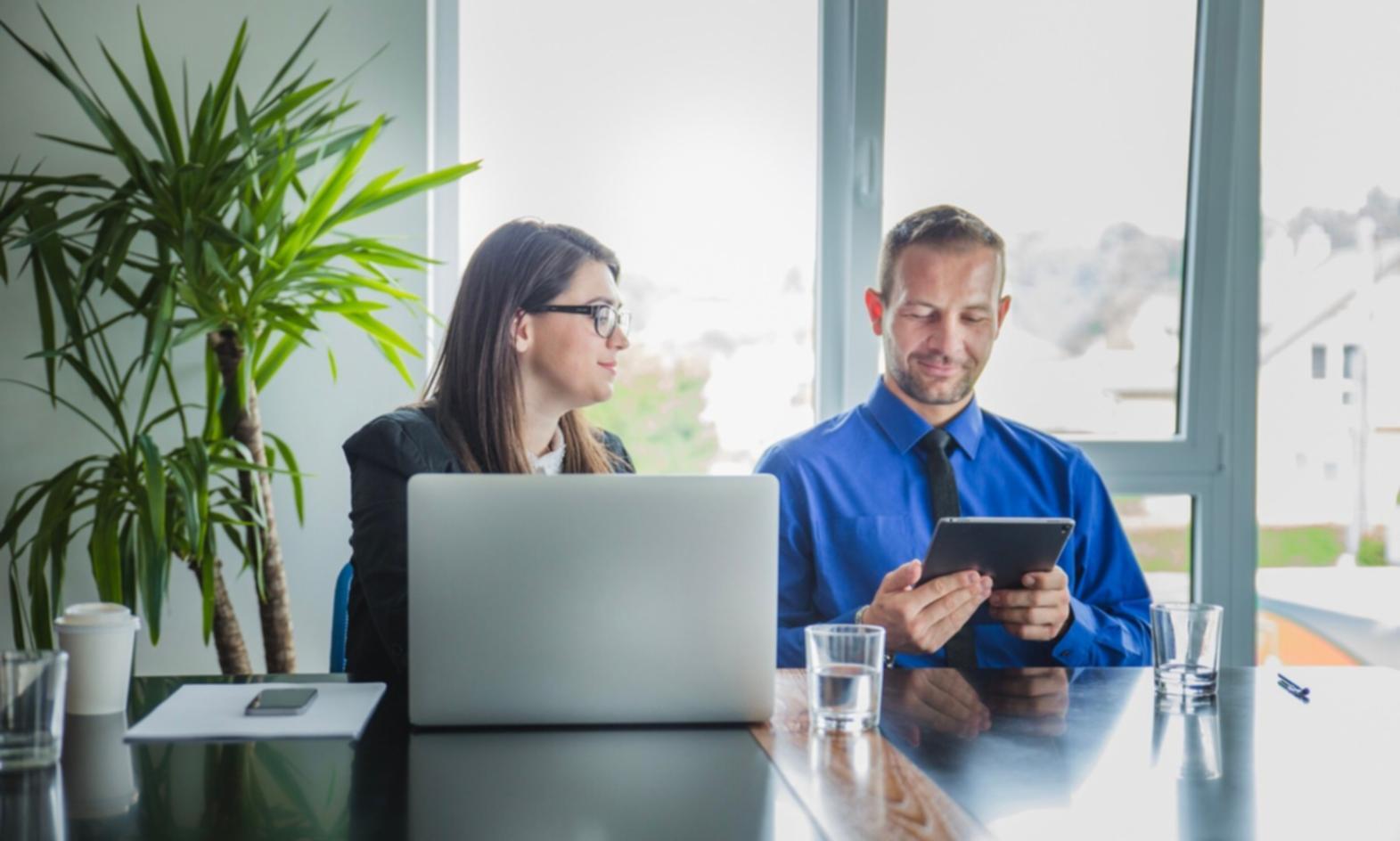 Personne suivant une formation en ligne sur ordinateur avec bloc-notes